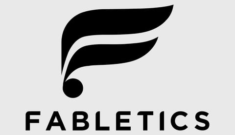 Fabletics logo featuring a stylized feather icon above the text Fabletics on a light gray background