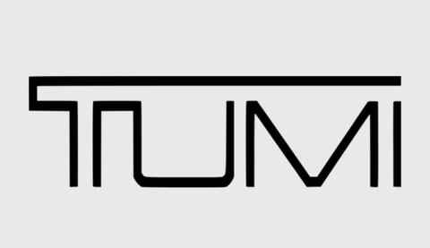 Stylized line drawing of the word TUMI in black outline against a light gray background
